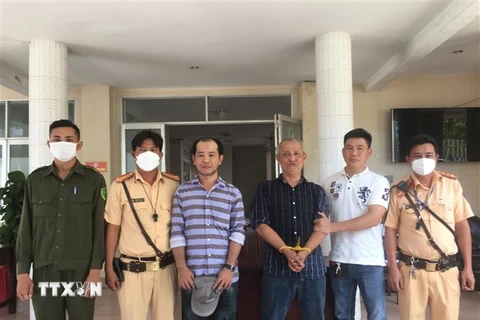 Trạm Cảnh sát giao thông thị xã Trảng Bàng tổ chức bàn giao 2 đối tượng trộm ôtô cho Công an thành phố Tây Ninh. (Ảnh: Thanh Tân/TTXVN)