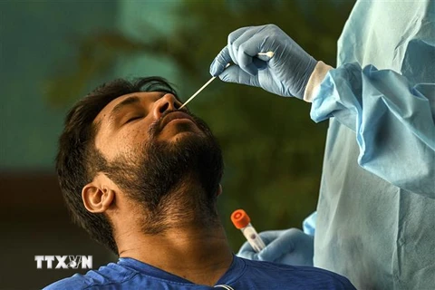 Nhân viên y tế lấy mẫu xét nghiệm COVID-19 cho người dân tại New Delhi, Ấn Độ. (Ảnh: AFP/TTXVN)