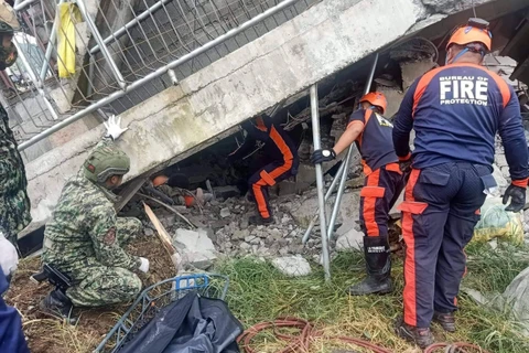 Lực lượng cứu hộ và cảnh sát nỗ lực đưa một người dân khỏi tòa nhà bị sập sau trận động đất. (Nguồn: EPA)