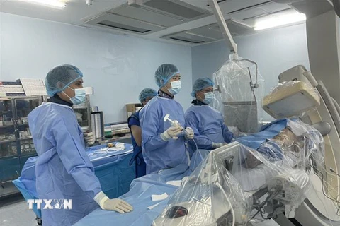 Các bác sỹ Bệnh viện huyện Bình Chánh phẫu thuật can thiệp tim mạch cho bệnh nhân đầu tiên. (Ảnh: TTXVN phát)