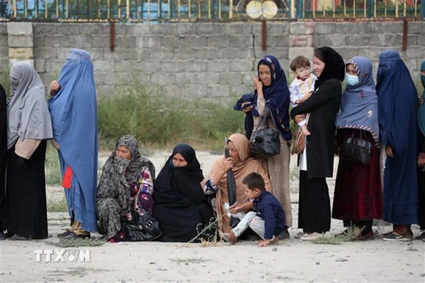 Phụ nữ và trẻ em Afghanistan xếp hàng chờ nhận lương thực cứu trợ tại Kabul. (Ảnh: THX/TTXVN)