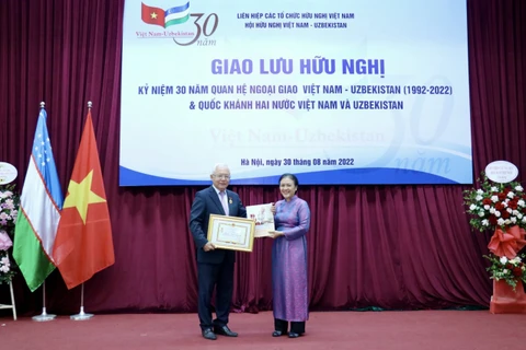 Chủ tịch Liên hiệp các tổ chức hữu nghị Việt Nam Nguyễn Phương Nga trao tặng Kỷ niệm chương 'Vì hòa bình hữu nghị giữa các dân tộc' cho ông Alisher Mukhamedov. (Nguồn: Thời Đại)