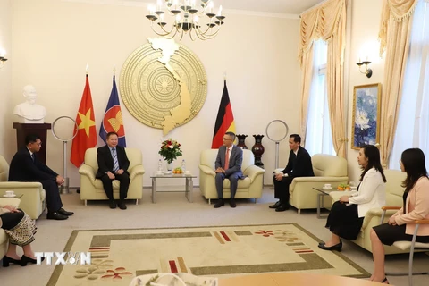 Đại sứ Vũ Quang Minh (thứ 4, phải sang) trao đổi với Đại sứ Lào Phomma Boutthavong (thứ 3, trái sang). (Ảnh: Mạnh Hùng/TTXVN)
