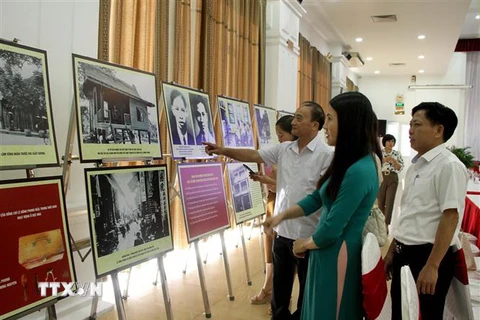 Các đại biểu tham quan những hình ảnh về cuộc đời sự nghiệp của Tổng Bí thư Lê Hồng Phong tại hội thảo. (Ảnh: Văn Tý/TTXVN)