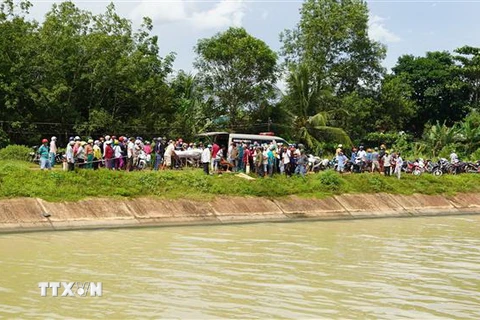 Thi thể người mẹ được trục vớt cách hiện trường (nơi nghi vấn người mẹ cùng 2 con nhảy kênh) khoảng 50m. (Ảnh: Thanh Tân/TTXVN)