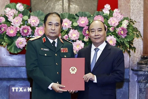Chủ tịch nước Nguyễn Xuân Phúc trao quyết định thăng quân hàm Thượng tướng cho ông Phùng Sĩ Tấn. (Ảnh: Thống Nhất/TTXVN)