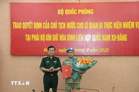 Thượng tướng Hoàng Xuân Chiến trao Quyết định của Chủ tịch nước cho Thiếu tá Bùi Văn Nhung làm nhiệm vụ quan sát viên quân sự tại Phái bộ Gìn giữ hòa bình Liên hợp quốc ở Cộng hòa Nam Sudan. (Ảnh: TTXVN/phát)