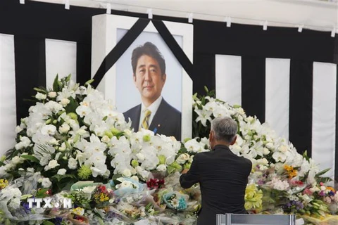 Một người đàn ông Nhật Bản bày tỏ lòng thành kính trước di ảnh của cố Thủ tướng Abe. (Ảnh: Đào Thanh Tùng/TTXVN)
