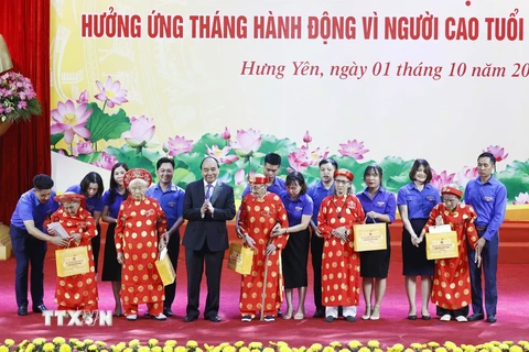 Chủ tịch nước Nguyễn Xuân Phúc tặng quà các cụ cao tuổi tại buổi lễ. (Ảnh: Thống Nhất/TTXVN)