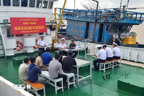 Vùng 3 Hải quân tiến hành bàn giao tàu cá và 7 ngư dân cho lực lượng chức năng thành phố Đà Nẵng. (Ảnh: Quốc Dũng/TTXVN)