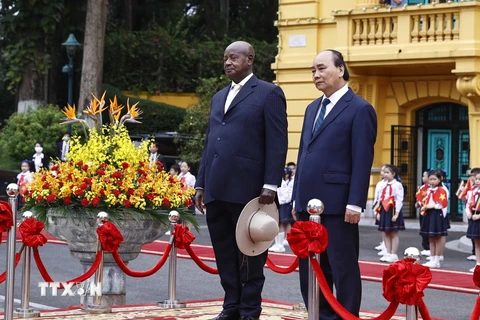 Chủ tịch nước Nguyễn Xuân Phúc và Tổng thống Uganda Yoweri Kaguta Museve nghe quân nhạc cử Quốc thiều hai nước. (Ảnh: Thống Nhất/TTXVN)