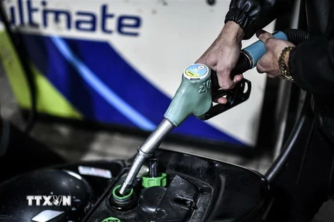 Bơm xăng cho phương tiện tại một trạm xăng ở Paris, Pháp. (Ảnh: AFP/TTXVN)