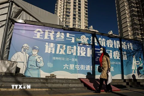 Người dân đeo khẩu trang phòng lây nhiễm COVID-19 ở Bắc Kinh, Trung Quốc. (Ảnh: AFP/TTXVN)