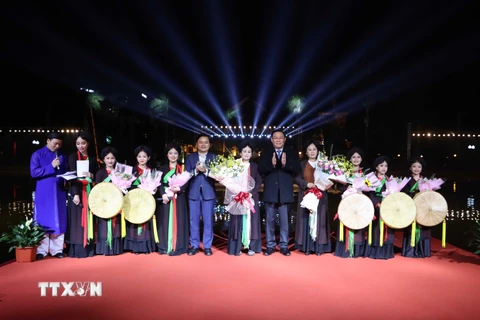 Chủ tịch Quốc hội Vương Đình Huệ tặng hoa chúc mừng các nghệ nhân quan họ và thiếu nhi tham gia biểu diễn dân ca quan họ Bắc Ninh. (Ảnh: Thanh Thương/TTXVN)