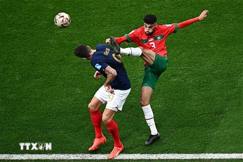 Pha tranh bóng giữa tiền đạo Pháp Olivier Giroud (trái) và hậu vệ Maroc Noussair Mazraoui. (Ảnh: AFP/TTXVN)