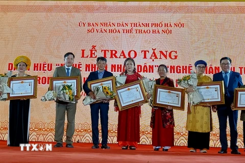 Trao tặng bằng vinh danh nghệ nhân ưu tú cho các nghệ nhân trong lĩnh vực di sản văn hóa phi vật thể ở Hà Nội. (Ảnh: Đinh Thuận/TTXVN)