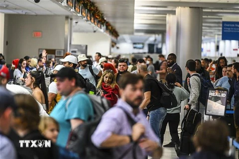 Hành khách chờ làm thủ tục tại sân bay quốc tế ở Miami, bang Florida, Mỹ. (Ảnh: AFP/TTXVN)