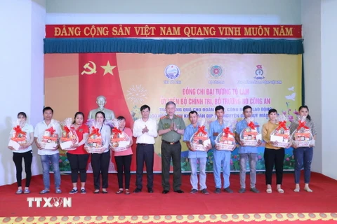 Đại tướng Tô Lâm, Ủy viên Bộ Chính trị, Bộ trưởng Bộ Công an và Bí thư Tỉnh ủy Tây Ninh Nguyễn Thành Tâm (áo trắng) tặng quà Tết cho công nhân. (Ảnh: Thanh Tân/TTXVN)