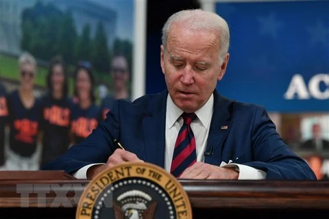Tổng thống Mỹ Joe Biden ký một đạo luật tại Nhà Trắng. (Ảnh: AFP/TTXVN)