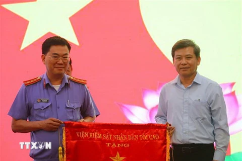 Viện trưởng Lê Minh Trí trao cờ thi đua cho Phòng thực hành quyền công tố và kiểm sát điều tra án kinh tế-chức vụ - Phòng 3 Viện Kiểm sát Nhân dân TP.HCM. (Ảnh: Thành Chung/TTXVN)