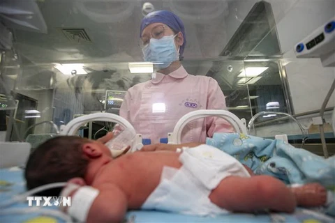 Nhân viên y tế chăm sóc em bé sơ sinh tại Trung Quốc. (Ảnh minh họa. Nguồn: AFP/TTXVN)