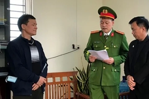 Bị can Nguyễn Mạnh Tuân (bên trái) nghe lệnh bắt. (Nguồn: Công an cung cấp)