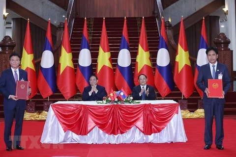 Thủ tướng Phạm Minh Chính và Thủ tướng Lào Sonexay Siphandone chứng kiến lễ ký Hiệp định tương trợ tư pháp dân sự giữa Việt Nam và Lào. (Ảnh: Dương Giang/TTXVN)