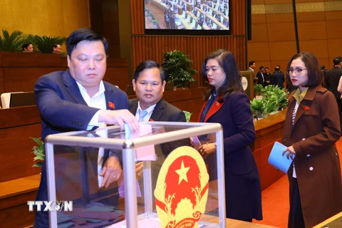 Đại biểu Quốc hội bỏ phiếu miễn nhiệm Chủ tịch nước Nguyễn Xuân Phúc. (Ảnh: Văn Điệp/TTXVN)