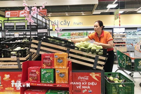 Nhân viên siêu thị Thành phố Hồ Chí Minh bổ sung thêm hàng hóa lên quầy, kệ vào sáng 23/1. (Ảnh: Mỹ Phương/TTXVN)