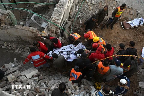 Lực lượng cứu hộ chuyển thi thể nạn nhân tại hiện trường vụ nổ trong đền thờ ở Peshawar, Pakistan, ngày 30/1. (Ảnh: AFP/TTXVN)
