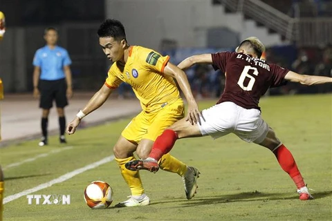 Pha tranh bóng giữa các cầu thủ đội Thành phố Hồ Chí Minh (áo nâu) và đội Khánh Hòa (áo vàng). (Ảnh: Thanh Vũ/TTXVN)