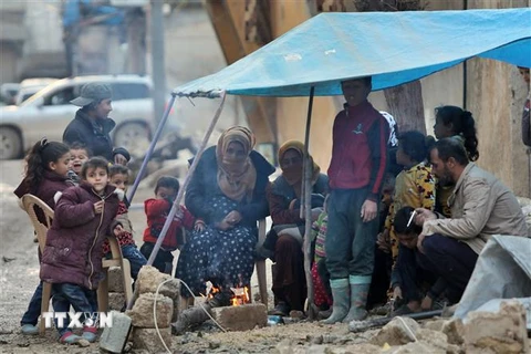 Người dân đốt lửa sưởi ấm trong thời tiết giá lạnh do bị mất nhà cửa sau trận động đất tại Jindayris, Syria. (Ảnh: AFP/TTXVN)