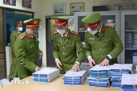 Công an niêm phong, thu giữ hồ sơ, tài liệu tại một trung tâm đăng kiểm ở Hà Nội. (Nguồn: TTXVN phát)