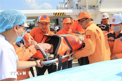 Các nhân viên Trung tâm Phối hợp tìm kiếm, cứu nạn hàng hải Việt Nam đưa thuyền viên người nước ngoài bị bệnh vào bờ an toàn. (Ảnh: Phan Sáu/TTXVN)