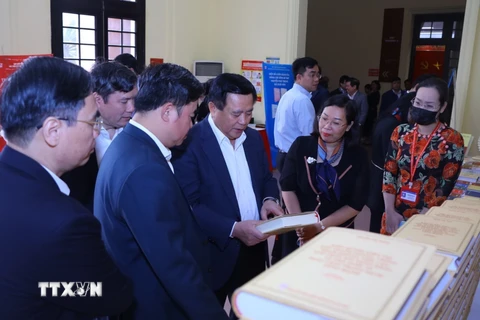 Ông Nguyễn Xuân Thắng với các đại biểu tham quan trưng bày sách. (Ảnh: Văn Điệp/TTXVN)