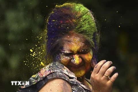 Một phụ nữ hứng được đủ thứ bột đầy màu sắc tại Lễ hội sắc màu Holi ở Mumbai, Ấn Độ ngày 7/3. (Ảnh: AFP/TTXVN)
