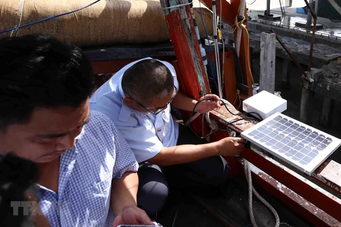 Thanh tra ngành thủy sản kiểm tra thiết bị giám sát hành trình khai thác thủy hải sản lắp đặt trên tàu cá của ngư dân. (Ảnh: Vũ Sinh/TTXVN)