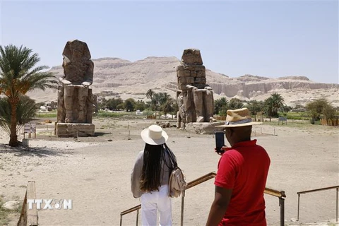 Khách du lịch ngắm Cặp tượng đá khổng lồ Memnon ở thành phố Luxor, Ai Cập. (Ảnh: AFP/TTXVN)