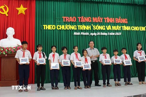 Trao máy tính bảng cho cho các em học sinh có hoàn cảnh khó khăn, vượt khó vươn lên trong học tập trên địa bàn huyện Ninh Phước. (Ảnh: Công Thử/TTXVN)