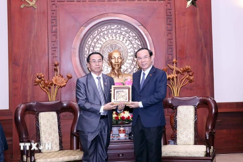 Bí thư Thành ủy Thành phố Hồ Chí Minh Nguyễn Văn Nên tặng phẩm lưu niệm cho ông Khampheng Vilaphanh. (Ảnh: Xuân Khu/TTXVN)