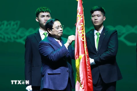 Thủ tướng Phạm Minh Chính gắn Danh hiệu Anh hùng Lao động lên cờ truyền thống Ngân hàng thương mại cổ phần Ngoại thương Việt Nam. (Ảnh: Dương Giang/TTXVN)