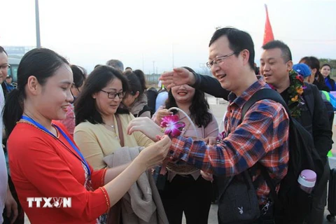 Đại diện các hãng lữ hành tại Khánh Hòa tặng hoa chào đón khách Macau, Trung Quốc. (Ảnh: Phan Sáu/TTXVN)