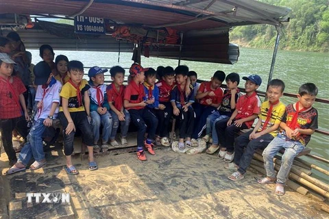 Các em học sinh làng Bèo Bọt, xã Cẩm Thành, huyện miền núi Cẩm Thủy, tỉnh Thanh Hóa phải đi thuyền vượt sông Mã. (Ảnh: Nguyễn Nam/TTXVN)