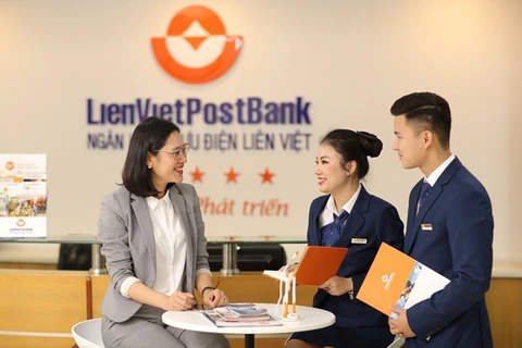 Cán bộ LienVietPostBank làm việc với khách hàng. (Ảnh: Vietnam+)