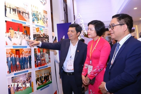 Các đại biểu tham quan trưng bày triển lãm ảnh về quan hệ Việt Nam-Pháp, hợp tác giữa các địa phương Việt Nam và Pháp. (Ảnh: Văn Điệp/TTXVN)