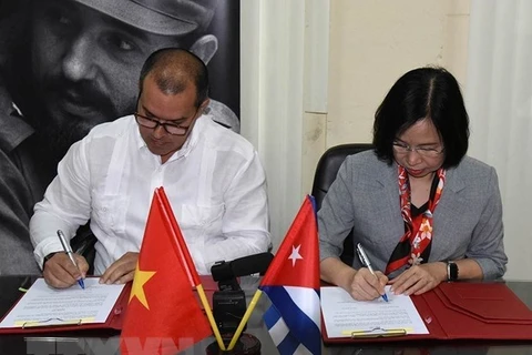 Tổng Giám đốc Thông tấn xã Việt Nam Vũ Việt Trang và Chủ tịch Prensa Latina Luis Enrique González Acosta ký thỏa thuận hợp tác mới. (Ảnh: Mai Phương/TTXVN)
