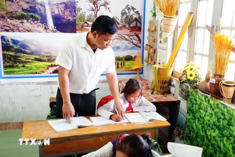 Thầy Nay Khôn hướng dẫn học sinh làm bài. (Ảnh: TTXVN phát)