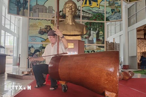 Nghệ nhân Võ Văn Bá sử dụng nhạc cụ đờn cò làm từ gốc dừa lớn nhất Việt Nam. (Ảnh: Huỳnh Phúc Hậu/TTXVN)