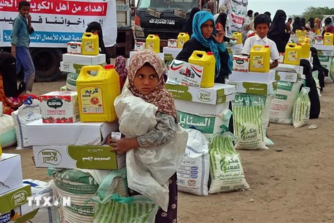 Người dân nhận hàng cứu trợ ở Hays, tỉnh Hodeida, miền Tây Yemen. (Ảnh: AFP/TTXVN)