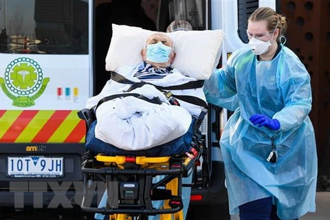 Nhân viên y tế chuyển bệnh nhân COVID-19 tại Melbourne, Australia. (Ảnh: AFP/TTXVN)